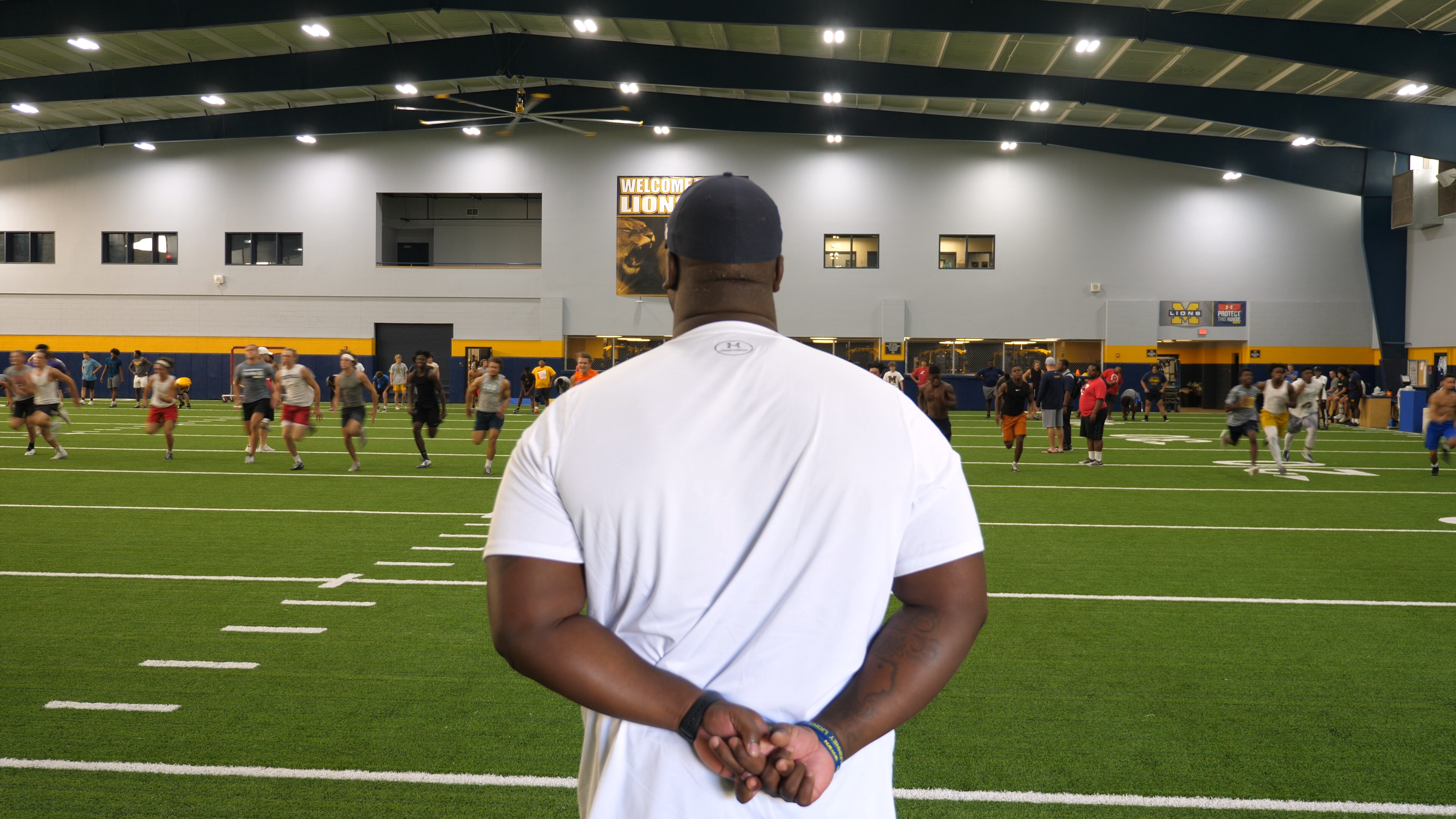 coach marcus shavers leading an indoor football practice at McKinny High Schol